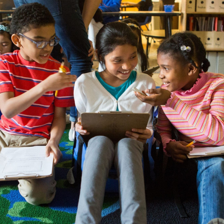 Group of three third graders Third graders discuss possible ways to solve a new math problem.