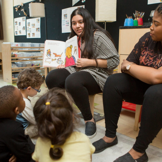 Student teachers read to class High school student teachers read a book to a preschool class.