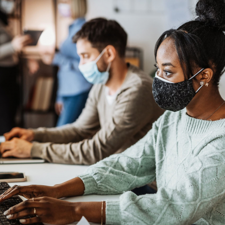 Diverse employees in office wearing double face masks Employees in office wearing double face masks during pandemic